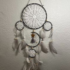 a white and black dream catcher hanging on the wall