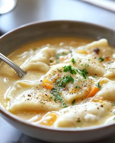 a bowl of soup with dumplings and carrots