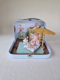 an open suitcase with a teddy bear sitting on the floor in front of it and other toys