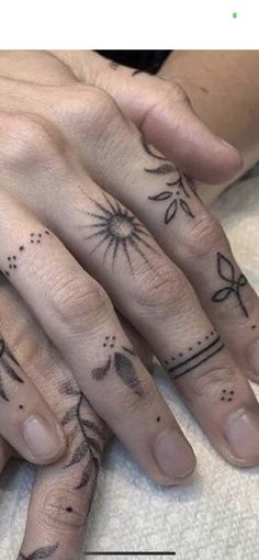 two fingers with tattoos on them and one has a bow, the other is a flower