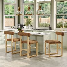 a kitchen with three stools in front of an island and two lights hanging from the ceiling