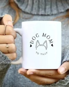 a woman holding a white coffee mug with the words dog mom to lily on it