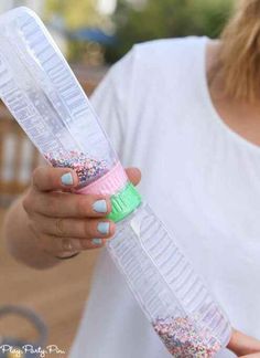 a woman holding a plastic container with sprinkles on it and a toothbrush