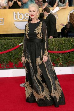 an older woman in a black and gold gown at the sag awards red carpet