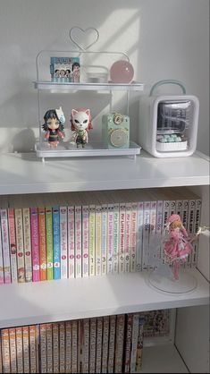 a shelf filled with lots of books on top of a white book case next to a microwave