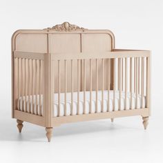 a wooden crib with white sheets on the bottom and sides, against a white background