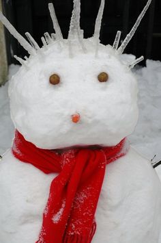 a snowman wearing a red scarf and hat with spikes on it's head