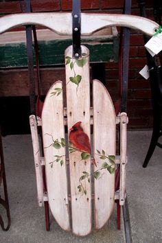 a wooden sled with a cardinal painted on it