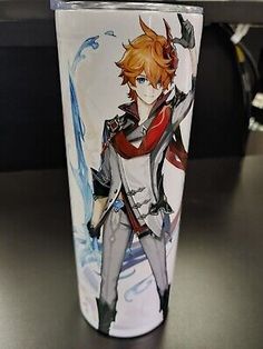 a glass with an anime character painted on the front and side, sitting on a table