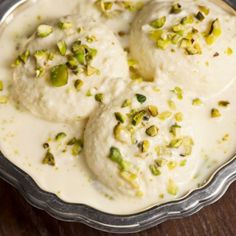 three scoops of mashed potatoes with pistachio seeds in a silver bowl