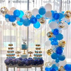 a blue and white dessert table with balloons