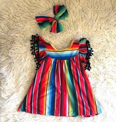 How fun and festive is this Serape Dress?!  And now in Pink! 💗 If you're anything like me, and love all things Serape, then you'll love this dress. ❤️   2-3t is 20" long, 3-4t  21" long and the 4-5t is 22" long.  Each dress is unique and color placement will vary. A bestseller for good reason! 💥 The Red Serape are finished and will be ready to ship next week 6/7!!  Woot woot! Order now so you don't miss out!More Razels! razels.etsy.com Fun Rainbow Dress For Playtime, Rainbow Dress For Birthday In Spring, Rainbow Dresses For Birthday In Spring, Fun Rainbow Playtime Dress, Fun Red Ruffled Dress, Rainbow Summer Dress For Playtime, Rainbow Summer Dresses For Playtime, Summer Rainbow Playtime Dress, Festive Multicolor Ruffle Dresses