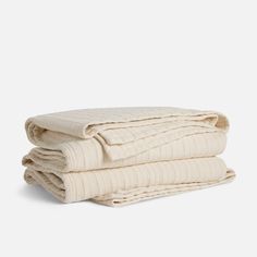 three folded blankets stacked on top of each other