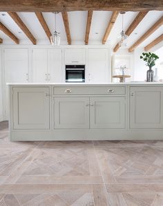 a large kitchen with white cabinets and wood beams on the ceiling is pictured in this image