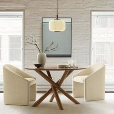 a dining room table with two chairs and a vase on the table next to it