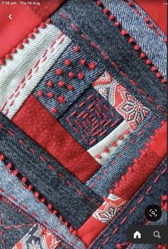 a close up of a patchwork piece of cloth with red and blue colors on it