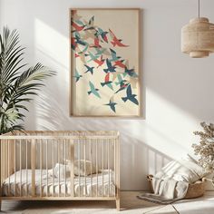 a baby's room with a crib, plant and artwork on the wall