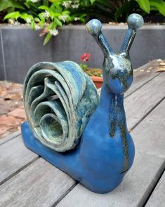 a blue snail statue sitting on top of a wooden table