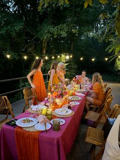 a group of people sitting around a table with food