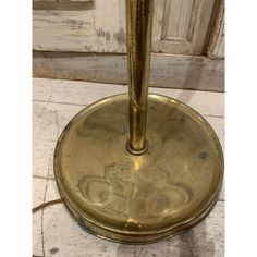 an antique brass umbrella stands on the floor