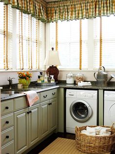 a kitchen with green cabinets and white washer and dryer in the corner next to the window