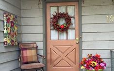 the front door is decorated with wreaths and flowers on it's side porch