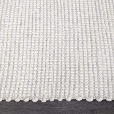 a white rug on top of a wooden floor