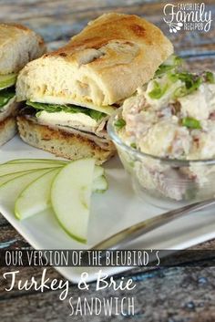 there is a plate with two sandwiches and a pickle on the side that says our version of the bluebird's turkey & brie sandwich sandwhich