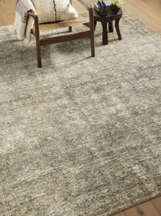 a living room area with a couch, coffee table and rug on the hardwood floor