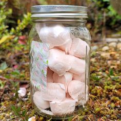 a jar filled with marshmallows sitting on the ground