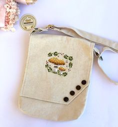 an embroidered bag sitting on top of a white table