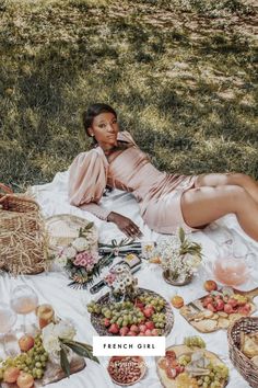 a woman laying on top of a blanket covered in food