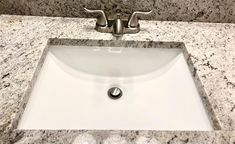 a white sink sitting on top of a marble counter