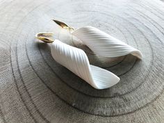 two white earrings sitting on top of a table