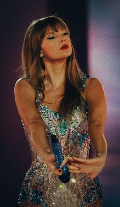 a woman in a sequin dress holding a microphone