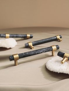 four black and gold cleaning brushes sitting on top of a bed