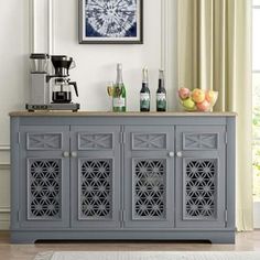 a gray cabinet with wine bottles on top in front of a window and a rug