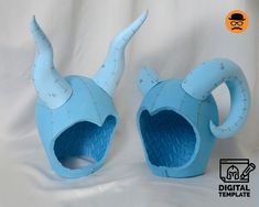 there are two blue sculptures made to look like animals with horns and tails on their heads