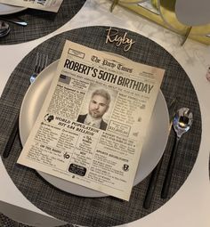 a newspaper sitting on top of a white plate next to silverware and napkins