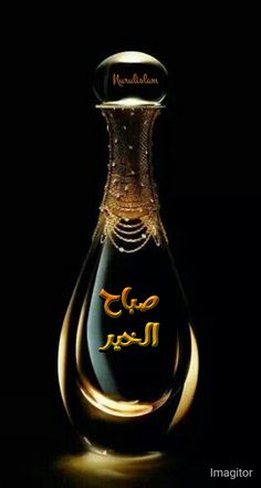 a bottle with arabic writing on it sitting in front of a black background and gold trimmings