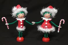 two christmas dolls are holding candy canes