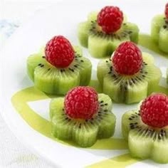 kiwis with raspberries are arranged on a plate