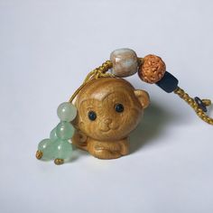 a small brown bear with beads on it's neck and a beaded necklace