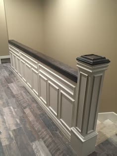 an empty room with wood flooring and a white bar in the middle of it