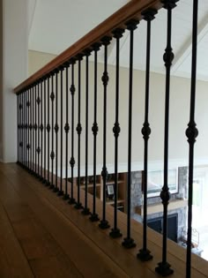 a wooden floor with black iron railings and wood hand rails on the bottom level