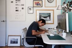 a man sitting at a desk with a computer and papers in front of his face