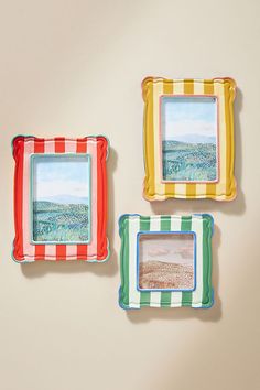 three colorful plates with pictures hanging on the wall