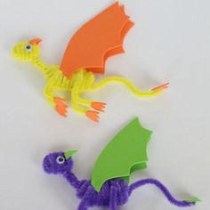 two paper dragon puppets sitting next to each other