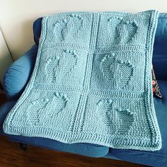 a crocheted blanket sitting on top of a blue couch