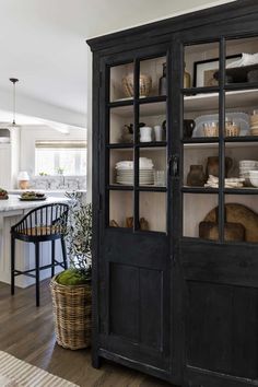 a black cabinet with glass doors in a kitchen